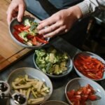 A professional chef prepares fresh vegetable plates in a modern kitchen setting.